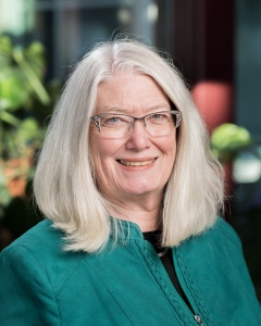 Profile photo of woman wearing glasses and green blazer
