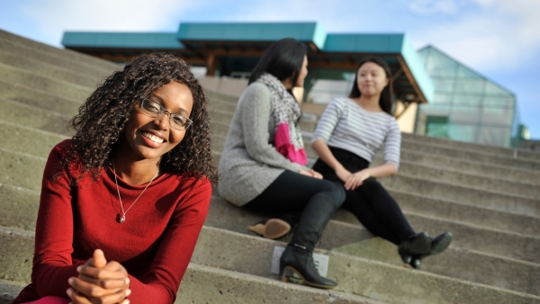 an image of 3 students on the stairs at UNBC