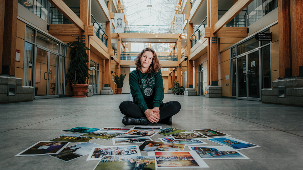 UNBC student with photos on floor