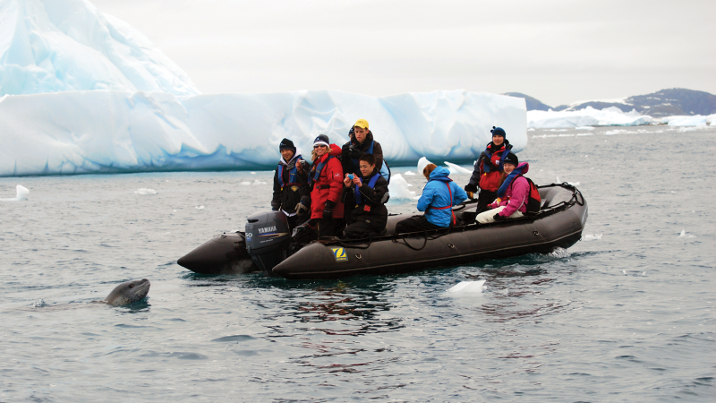 UNBC students on a boat beside a glacier