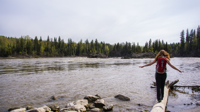 Photo of student walking on a log in Fort George Canyon