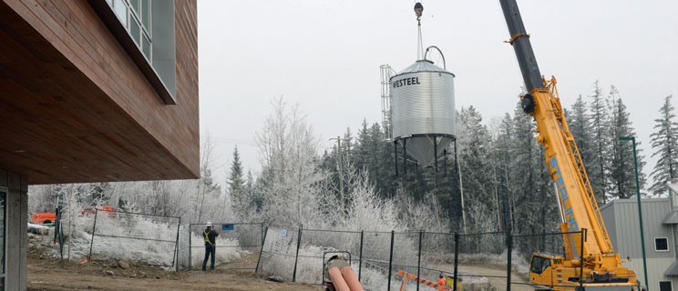 Workers use a crane to move the fuel silo from the EFL to the Bioenergy Plant