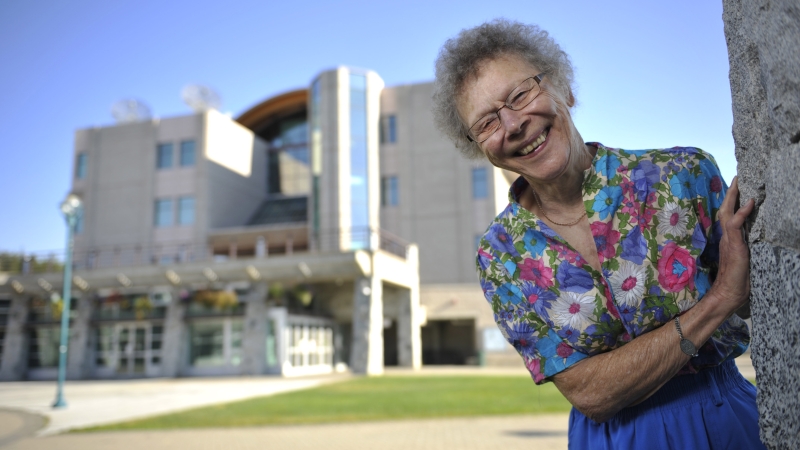 Dr. Elsie Gerdes at the UNBC Prince George campus with the library in the background 
