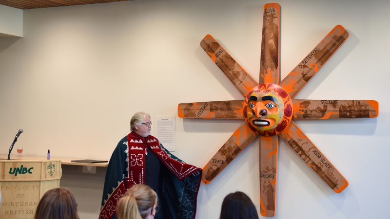 Winadzi talks about his new installation Reconciling Light. The artwork has a face in the middle with eight rays each featuring one phase of the Residential School story 