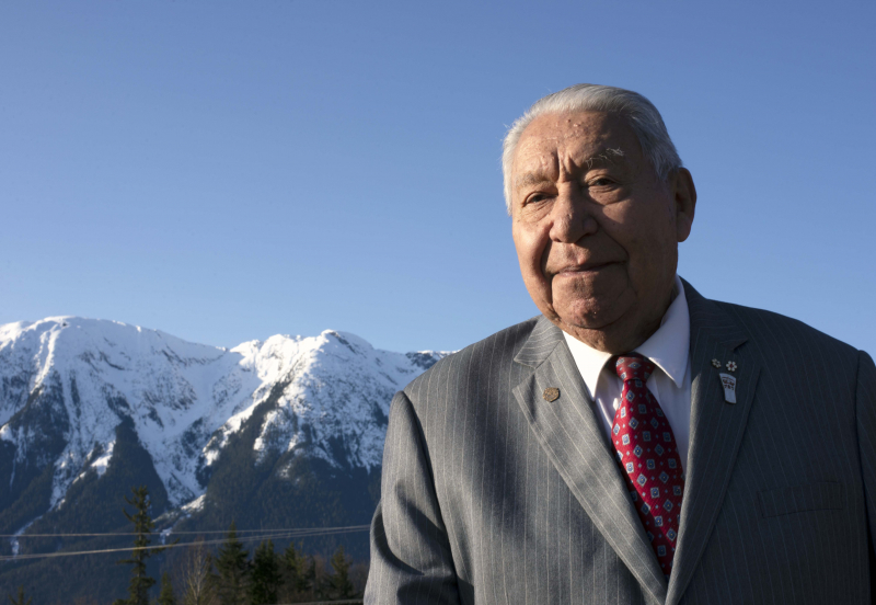 Joseph Gosnell Sr standing in the Nass Valley with mountains in the background.