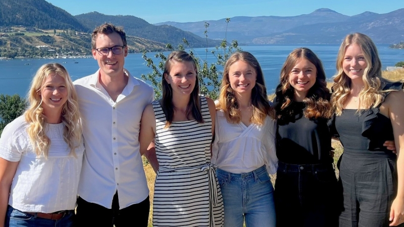 Group photo of the six Koopmans siblings with a lake in the background