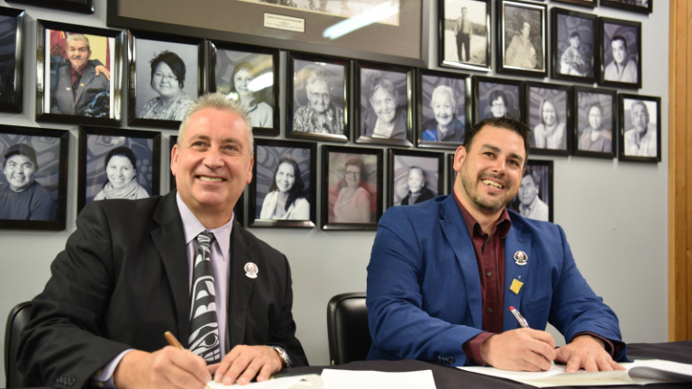 UNBC President Dr. Daniel Weeks and Lheidli T’enneh Nation chief Clay Pountney sign an Agreement.