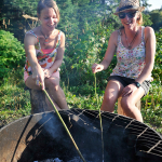 Students Gina Marie Donatria and Danielle Smart enjoy marshmallows over a fire pit at Shane Lake, just a short walk from UNBC's campus.