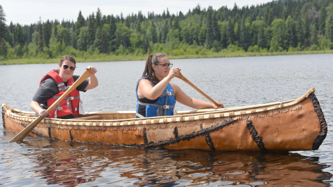 Students Nicole Hoffman and Jacey Wolfe paddle a birch bark canoe
