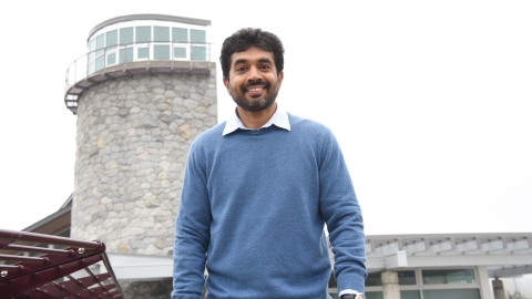Rajeev Pillay with the lighthouse feature of the UNBC campus in the backgrund 