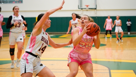 A player has the ball and looks to shoot with a defender nearby 